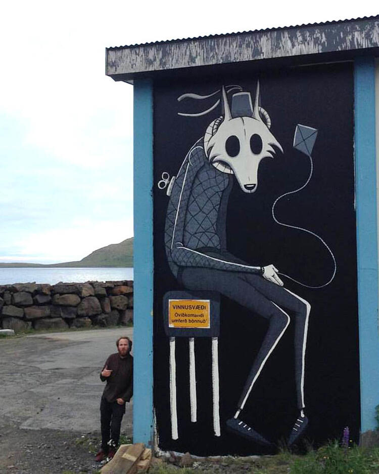 Street art featuring a whimsical, stylized fox in a suit sitting on a stool, with headphones. set in a coastal area.